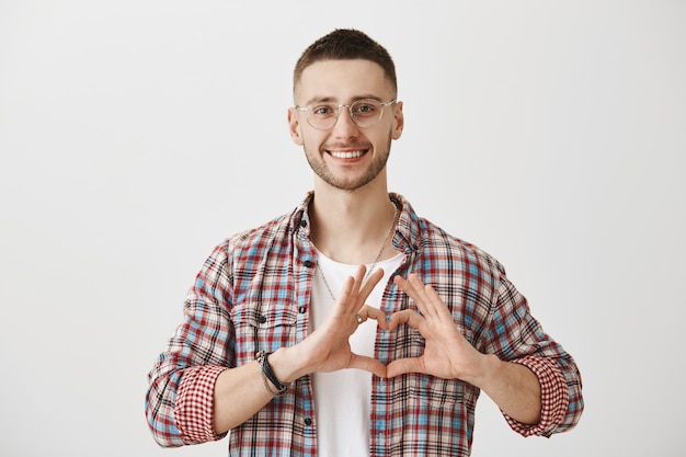 Beau jeune homme avec des lunettes posant