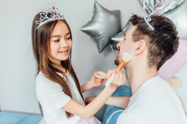 Beau jeune homme à la maison avec sa petite fille mignonne