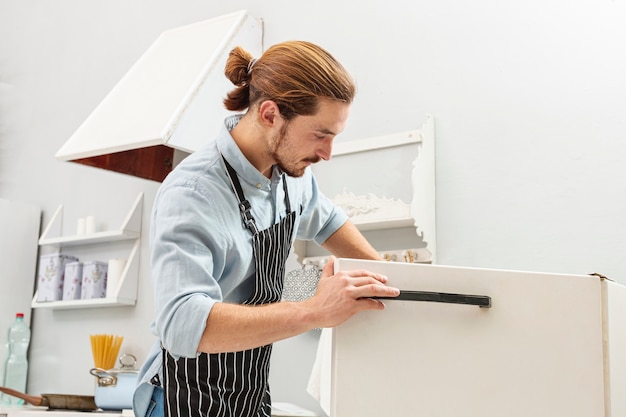 Beau jeune homme ouvrant un frigo