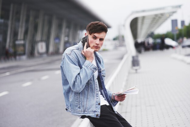 Un beau jeune homme parlant au téléphone près de l'espace de bureau.