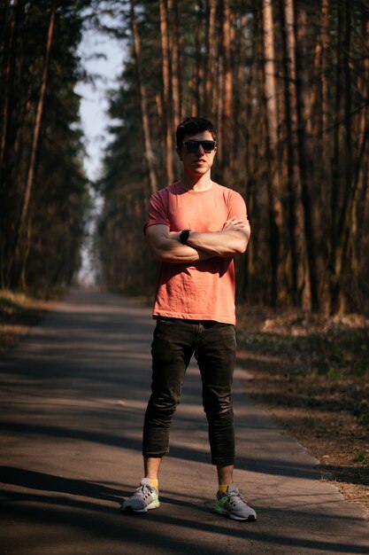 Beau jeune homme en plein air dans le parc, marcher dans le parc