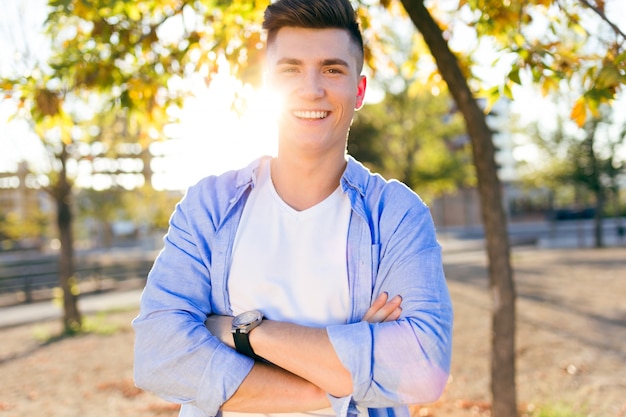 Beau jeune homme regardant la caméra dans le parc.