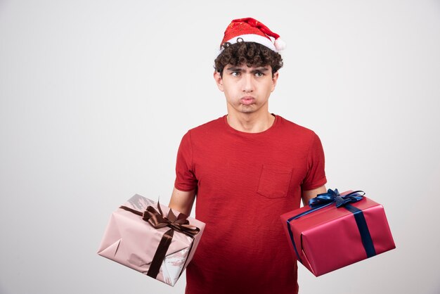 Beau jeune homme s'ennuie avec les coffrets cadeaux.