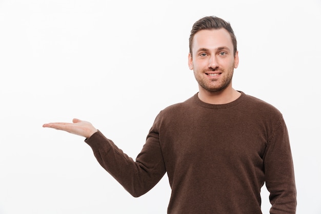 Beau jeune homme souriant montrant la surface