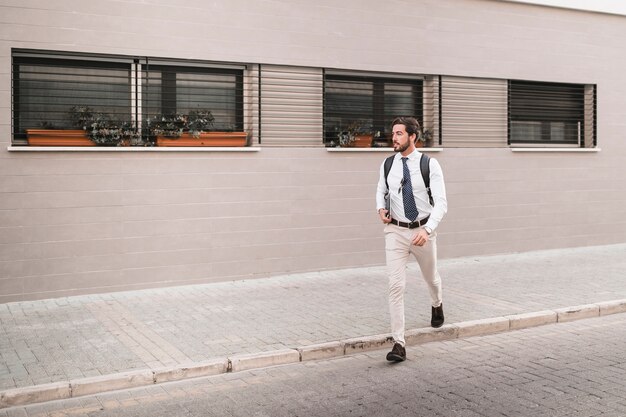 Beau jeune homme traversant la rue