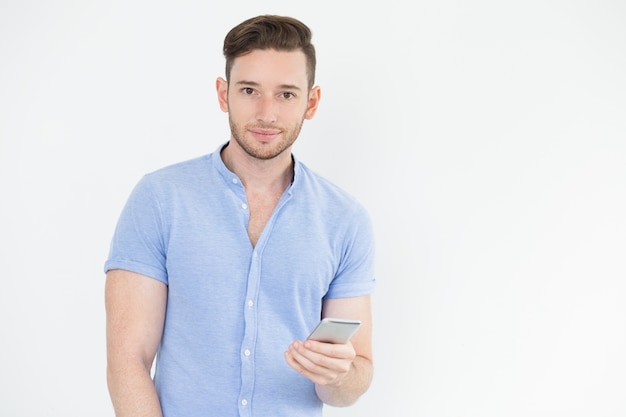 Beau jeune homme utilisant un smartphone