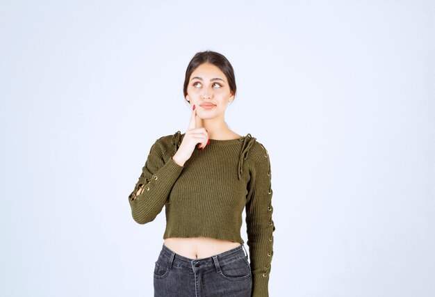 Un beau jeune mannequin en chemisier vert pensant à quelque chose