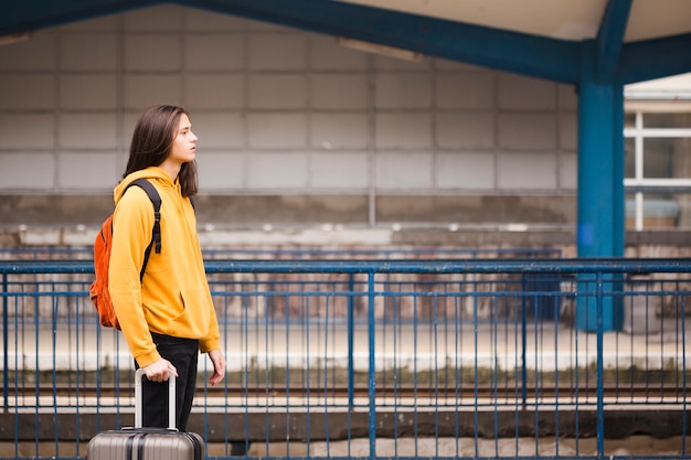 Photo gratuite beau jeune touriste attendant le train