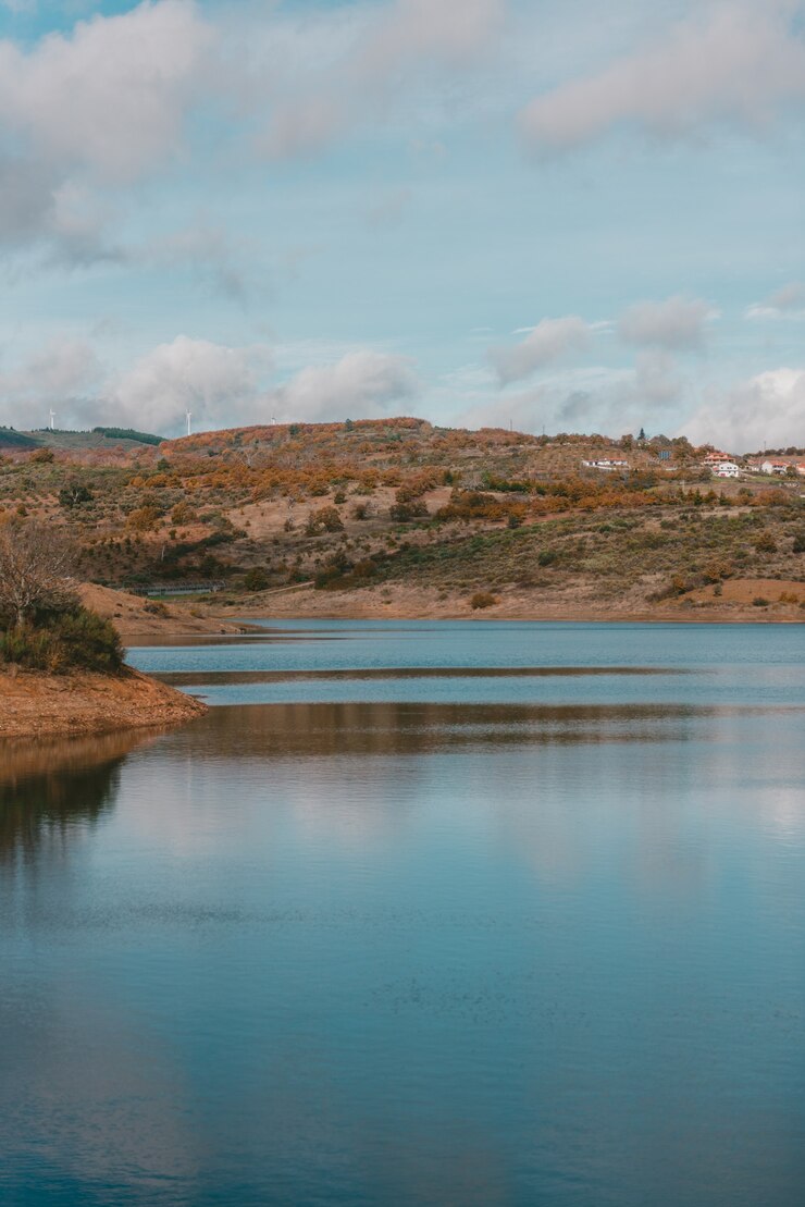 Photo gratuit beau lac entouré d'une chaîne de montagnes sous le ciel nuageux à couper le souffle