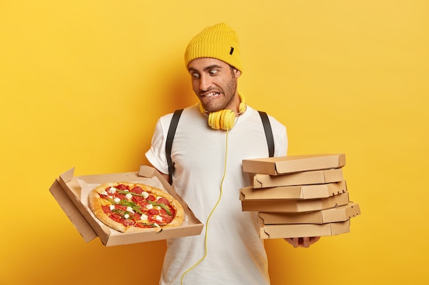 Photo gratuite beau livreur avec des boîtes à pizza