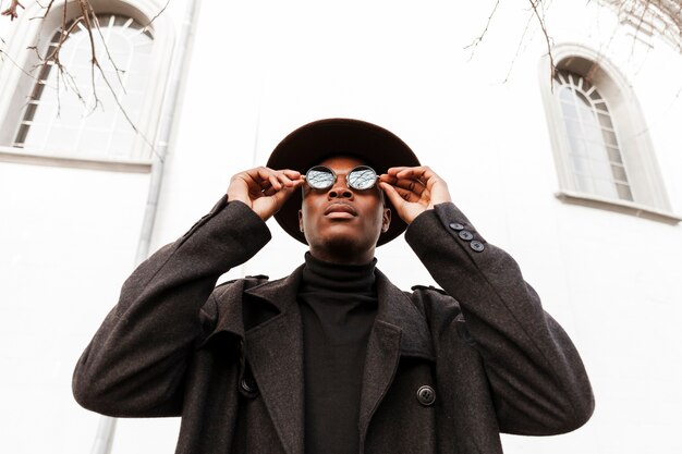 Beau mâle adulte avec des lunettes de soleil et un chapeau