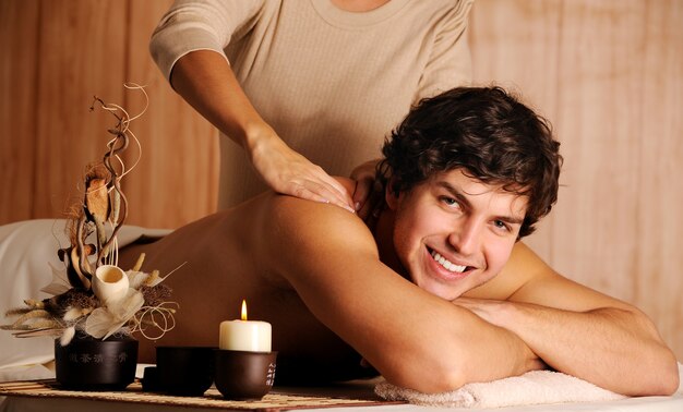 Beau mâle se massage de relaxation dans le salon de spa