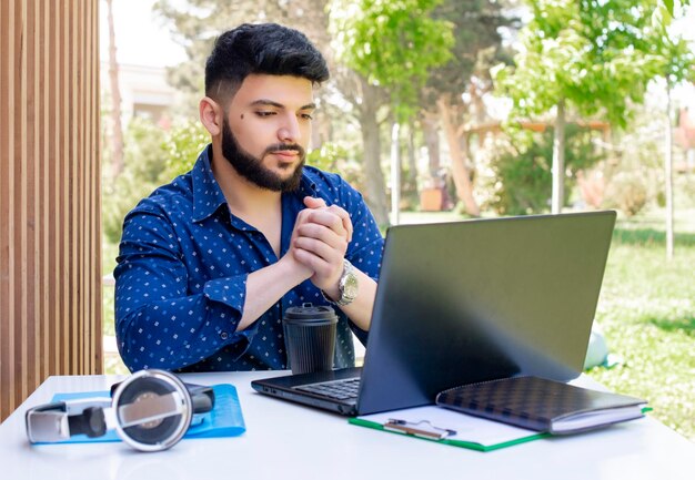 Beau mec asiatique travaillant sur un ordinateur portable en regardant l'écran