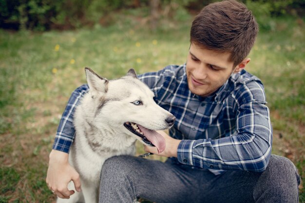 Beau mec dans un parc d&#39;été avec un chien