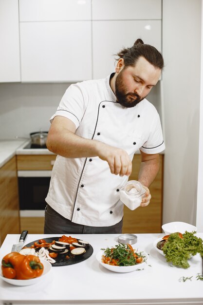 Beau mec debout dans la cuisine à la maison.