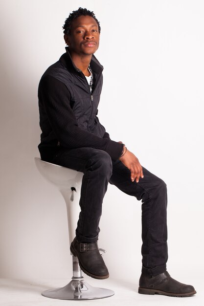 Beau mec noir assis sur une chaise