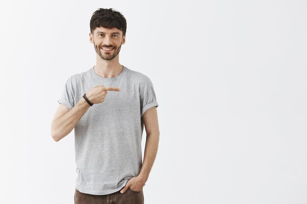 beau mec posant contre le mur blanc