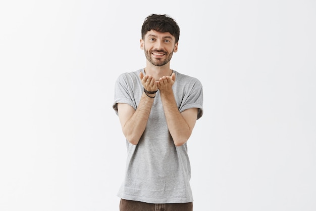 Beau mec romantique posant contre le mur blanc