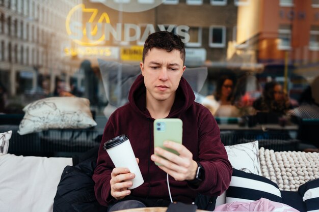 Beau mec traîner et se détendre dans un café en plein air