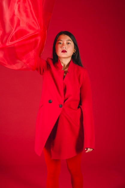 Beau modèle asiatique posant dans des vêtements rouges