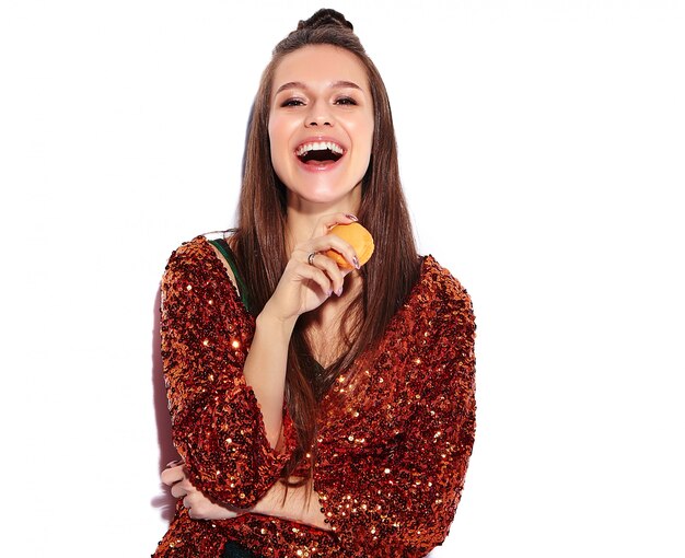 Beau modèle de femme brune hipster souriant caucasien en brillant brillant reflétant la veste élégante d'été et la robe verte isolée. Manger du macaron français