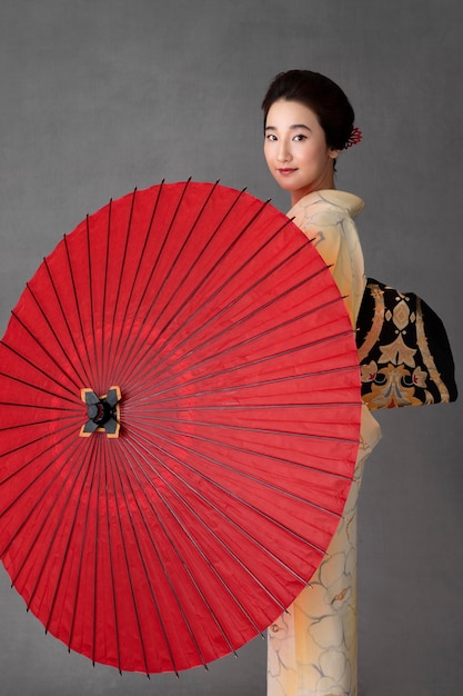 Beau modèle japonais avec un parapluie rouge