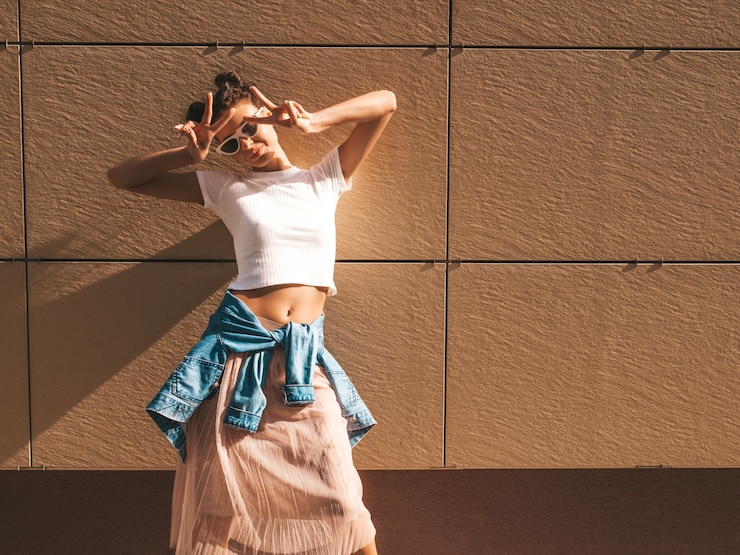 Photo gratuit beau modèle souriant avec des cornes coiffure habillée en vêtements de t-shirt blanc hipster d'été.fille insouciante sexy posant dans la rue près du mur.tendance femme drôle et positive s'amusant dans des lunettes de soleil