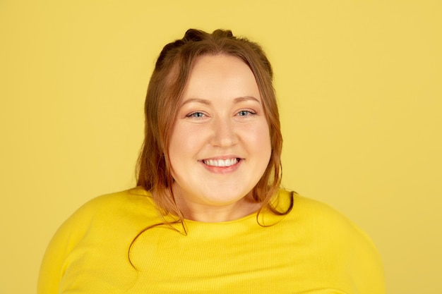 Photo gratuite beau modèle de taille plus caucasien isolé sur fond de studio jaune concept d'inclusion émotions humaines expression faciale