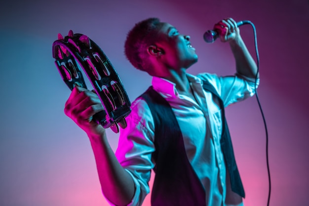 Beau musicien de jazz afro-américain jouant du tambourin et chantant.