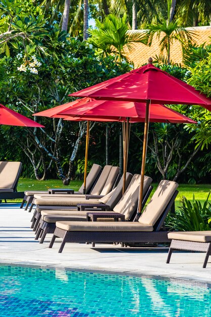 Beau parasol et chaise autour de la piscine extérieure de l’hôtel pour des vacances, un voyage