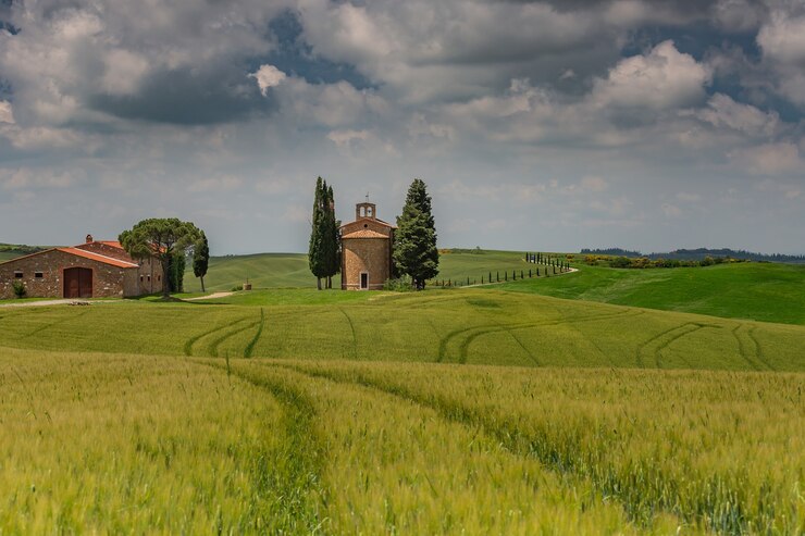 Photo gratuit beau paysage de champs de campagne entourés de collines sous le ciel sombre