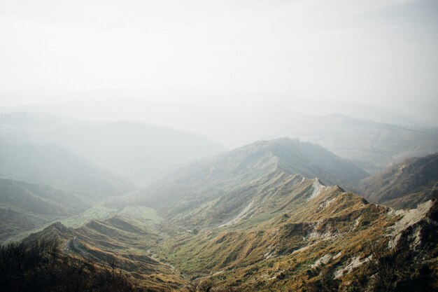 Beau paysage d'une gamme de montagnes vertes enveloppées de brouillard