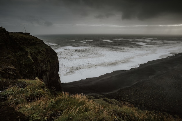 Beau paysage de la mer entouré de formations rocheuses enveloppées de brouillard en Islande