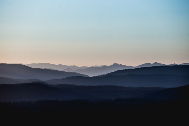 Beau paysage de montagnes et de collines sous un ciel rosé