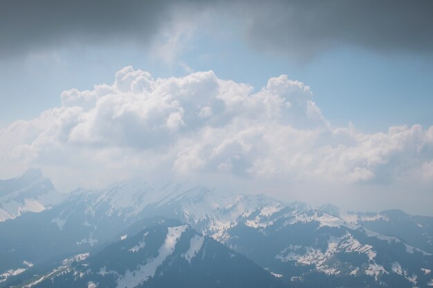 Beau paysage de nuages blancs couvrant la gamme de hautes montagnes rocheuses