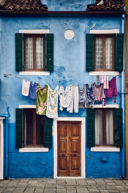 Beau plan symétrique vertical d'un immeuble bleu de banlieue avec des vêtements suspendus à une corde