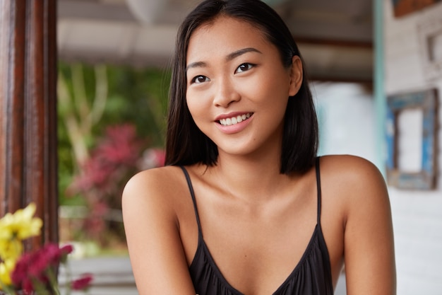 Photo gratuite beau portrait de femme chinoise avec une coiffure bobbed, pose dans une chambre confortable