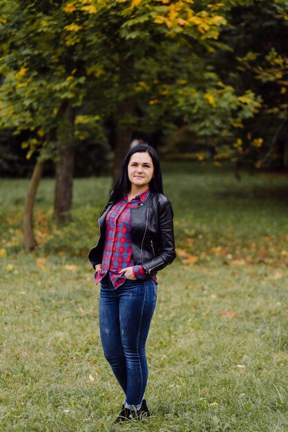 Beau portrait de fille d'automne. Jeune femme posant sur des feuilles jaunes dans le parc de l'automne. Extérieur