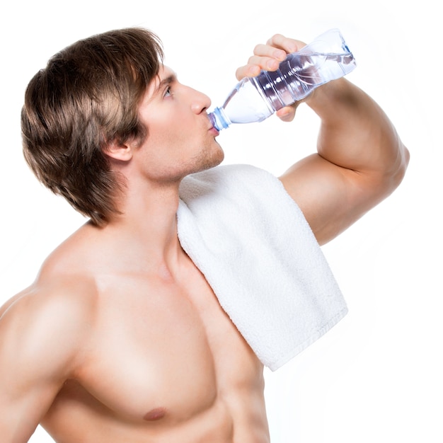 Beau Sportif Torse Nu Musclé Boit De L'eau - Isolé Sur Un Mur Blanc.