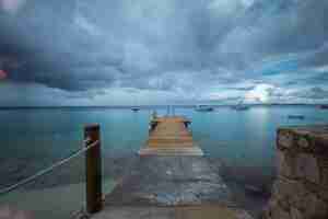 Photo gratuite beau tir d'une jetée menant à l'océan sous le ciel sombre à bonaire, caraïbes