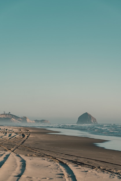 Beau tir d'une plage de sable avec des vagues incroyables sur une journée ensoleillée