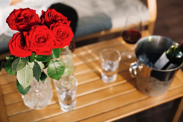 Beau vase de roses rouges sur table en bois