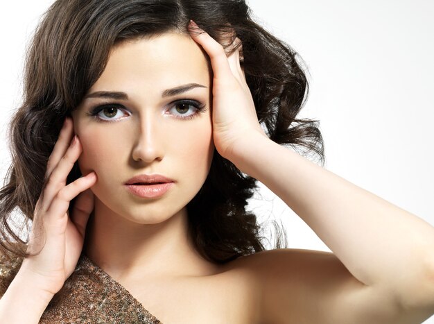 Beau visage de la jeune femme aux cheveux bruns bouclés