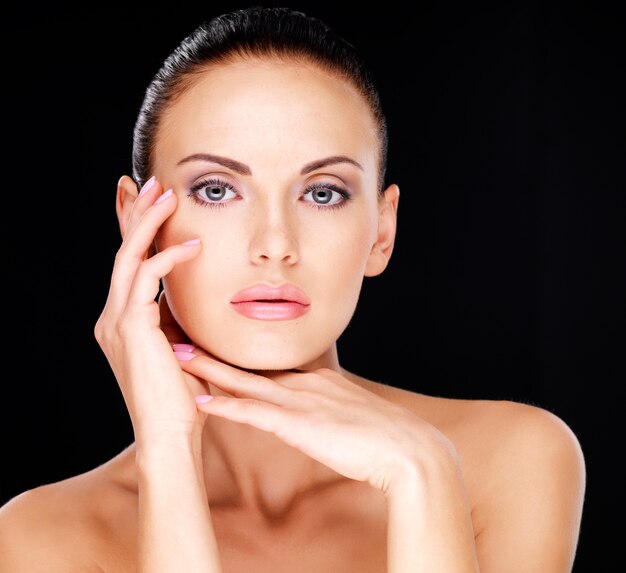 Beau visage sensuel de la femme adulte avec une peau fraîche - sur fond noir