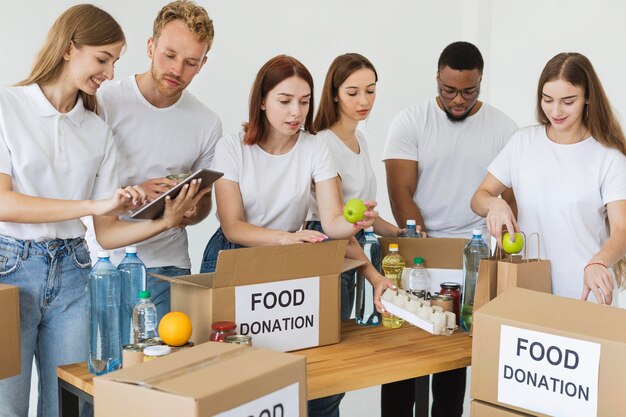 Beaucoup de bénévoles préparent des boîtes avec des dons alimentaires