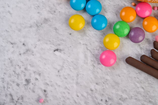 Beaucoup de bonbons multicolores placés sur une surface blanche.