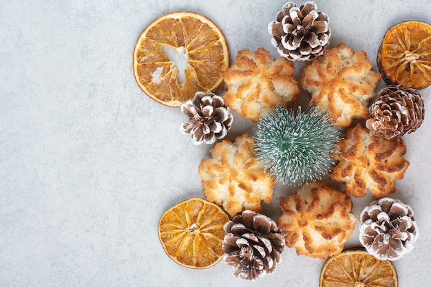 Beaucoup de délicieux biscuits frais avec de petites pommes de pin et des oranges séchées.