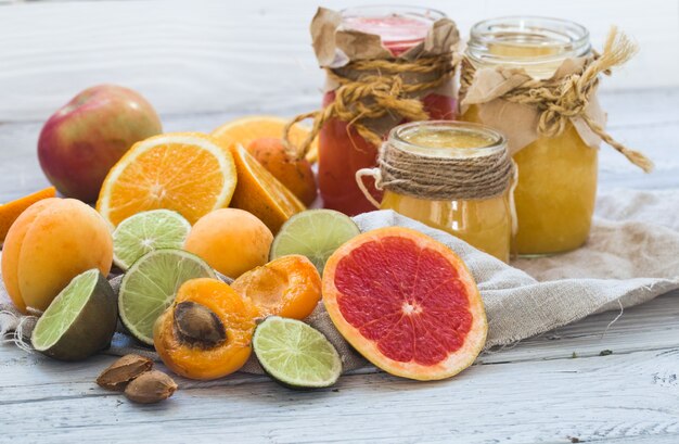 beaucoup de fruits frais, coupés sur un beau fond en bois, boisson aux fruits frais, confiture, nourriture savoureuse et saine