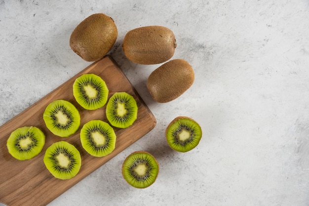 Beaucoup de fruits frais kiwi sur planche de bois.