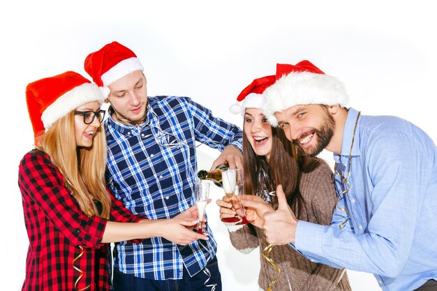 Beaucoup de jeunes femmes et hommes buvant à la fête de Noël sur studio blanc